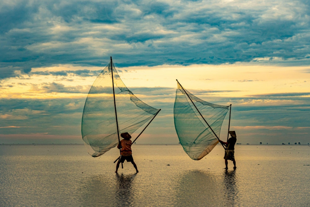 Local fishermen pull in nets at dawn, capturing the authentic rhythm of life at Bai Xep village center